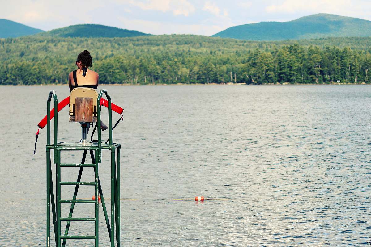 people women sitting on chair watching body of water person