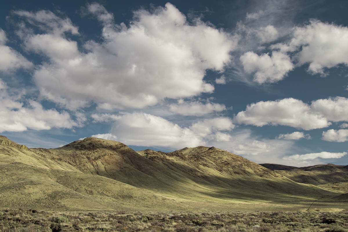 nature landscape photography of mountains covered with green grasses under cloudy sky outdoors