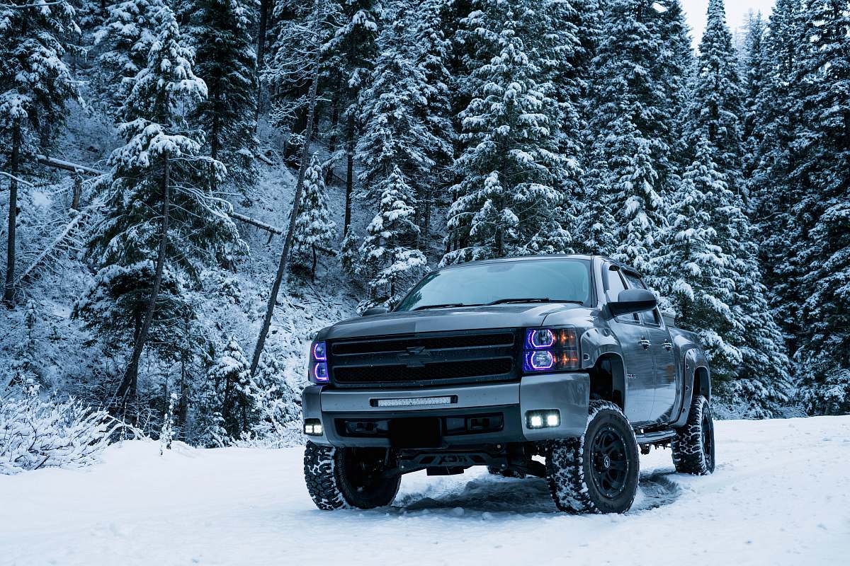 vehicle gray pickup truck on snow field surrounded by trees automobile