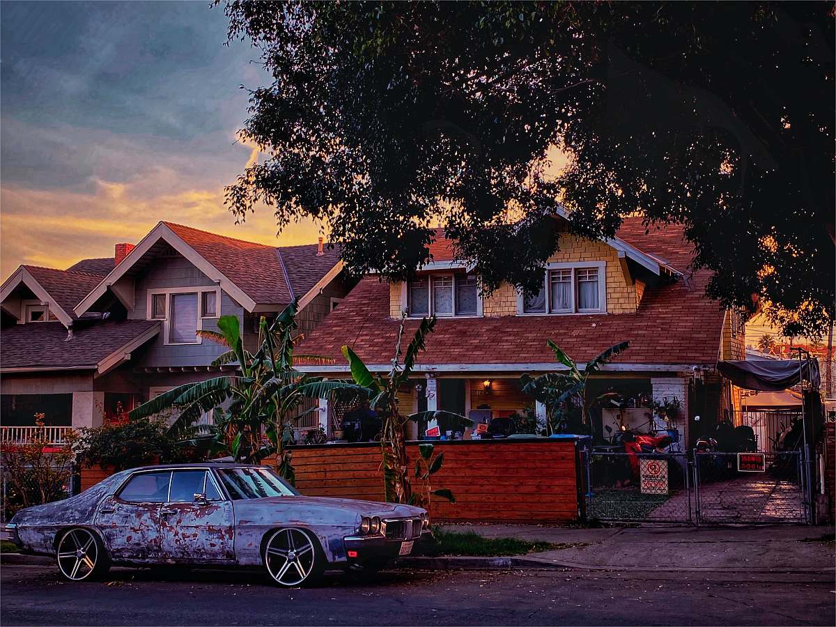 spoke black sedan parked beside brown wooden house during daytime alloy wheel