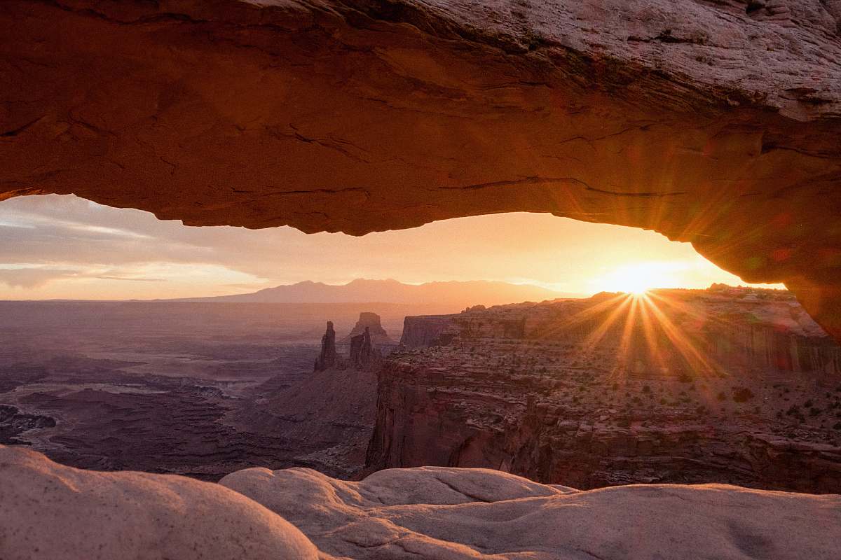 outdoors aerial photography of rocky mountain during sunset sun flare