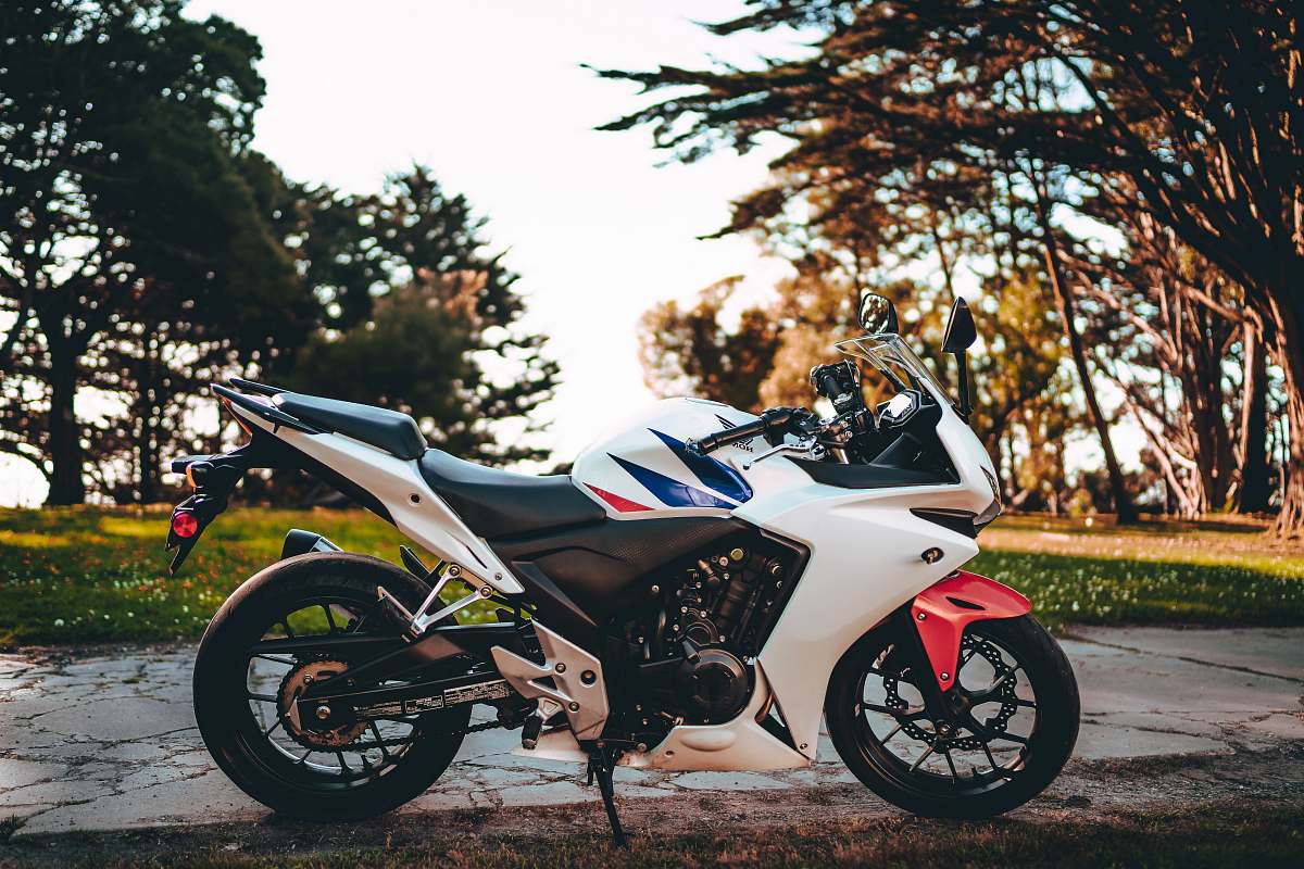 transportation white and black sports bike parked on gray concrete pavement during daytime vehicle