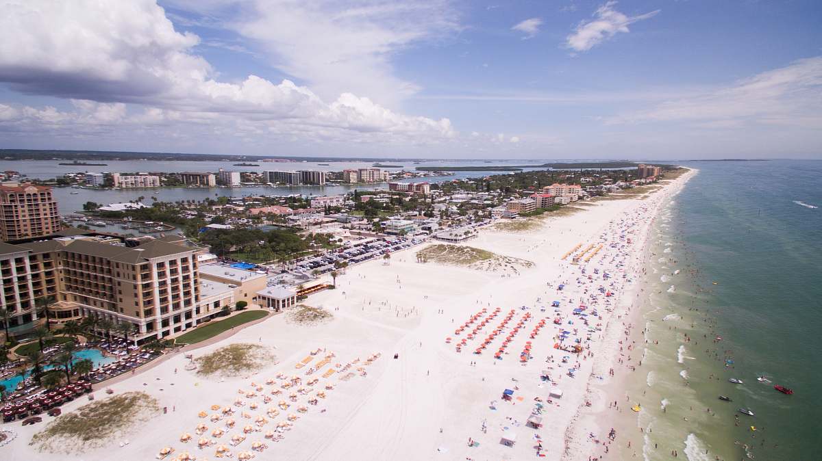 beach aerial photography of people on the beach across buildings at daytime coast