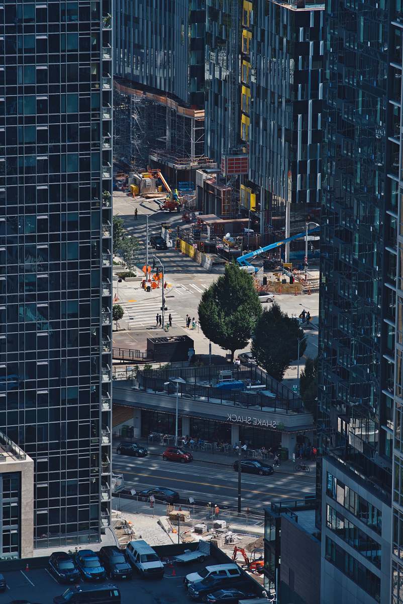 Explore a stunning aerial view capturing the intersection of bustling urban life and scenic landscapes. This breathtaking image showcases a dense cityscape adorned with towering skyscrapers, perfect for projects related to urban planning, architectural design, or promotional materials highlighting metropolitan living. The harmonious blend of nature and city life makes it an ideal choice for travel blogs, real estate advertisements, and city promotional campaigns.