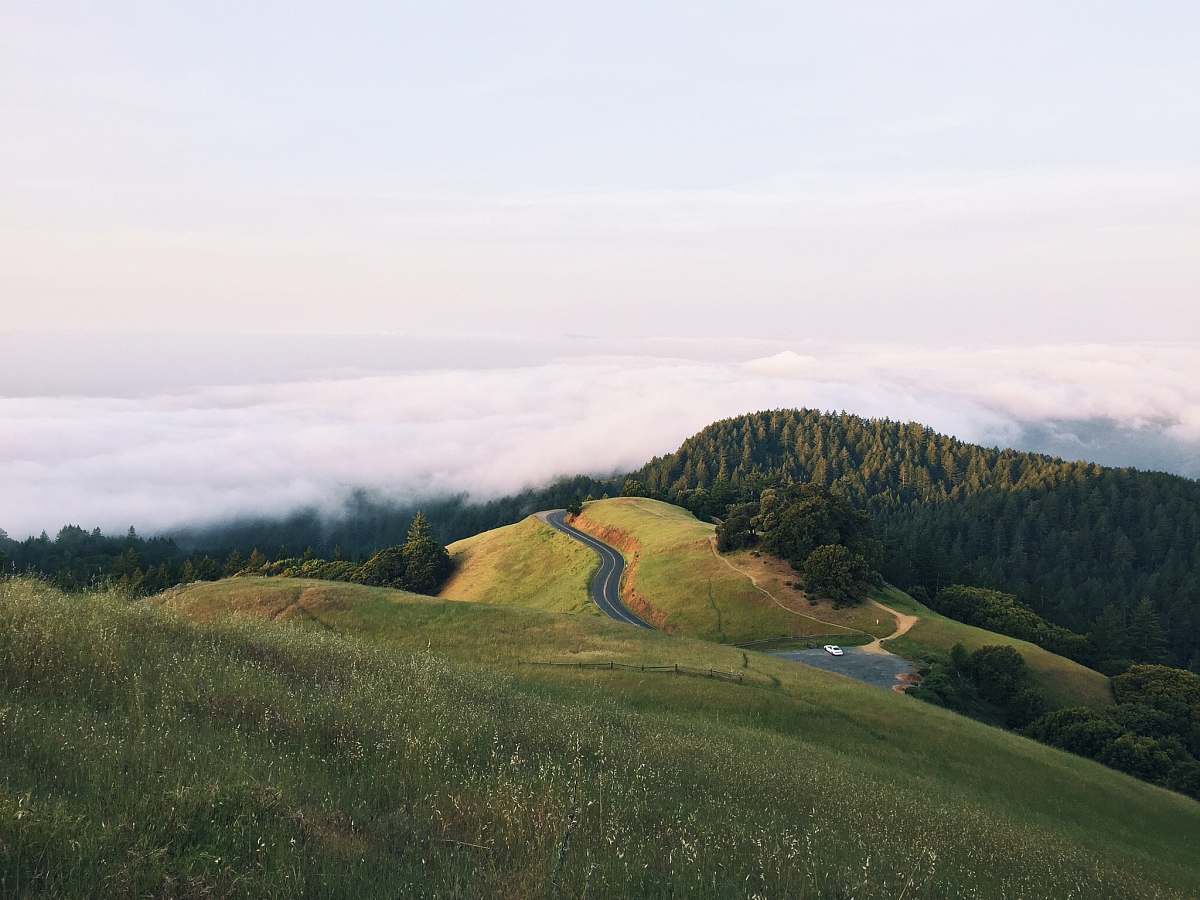landscape asphalt road between green grass field near mountains hill