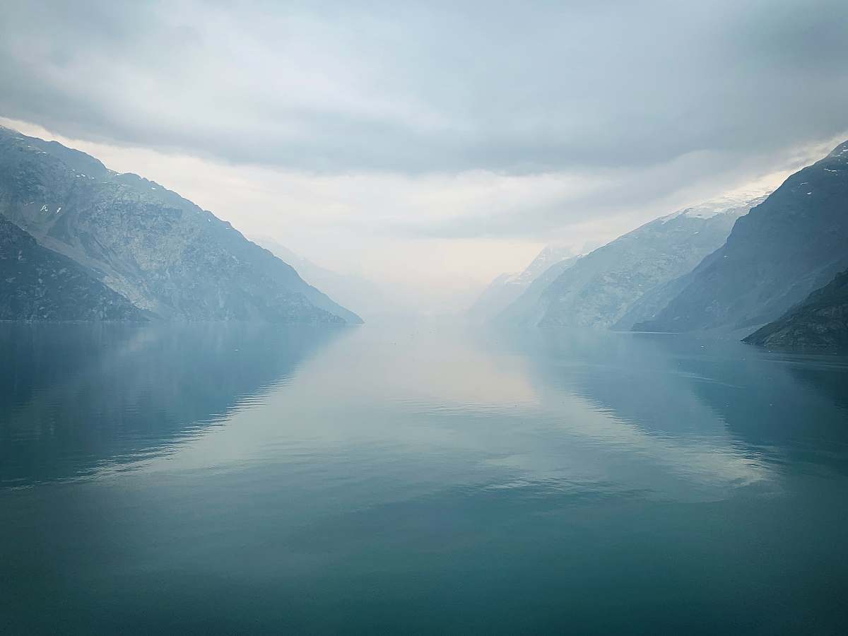 mountain body of water between mountain during daytime outdoors