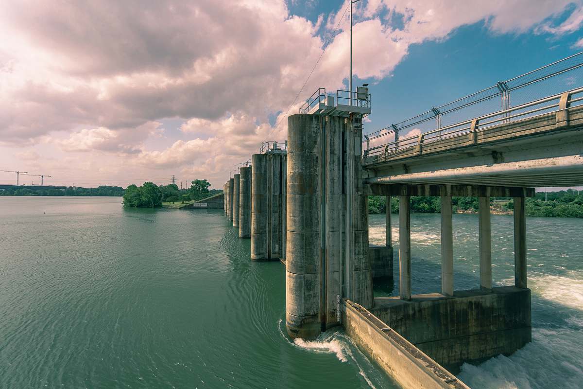 river brown concrete dam near trees during daytime water