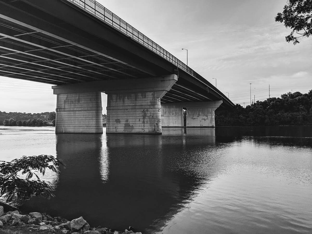 black-and-white grayscale photo of concrete bridge water