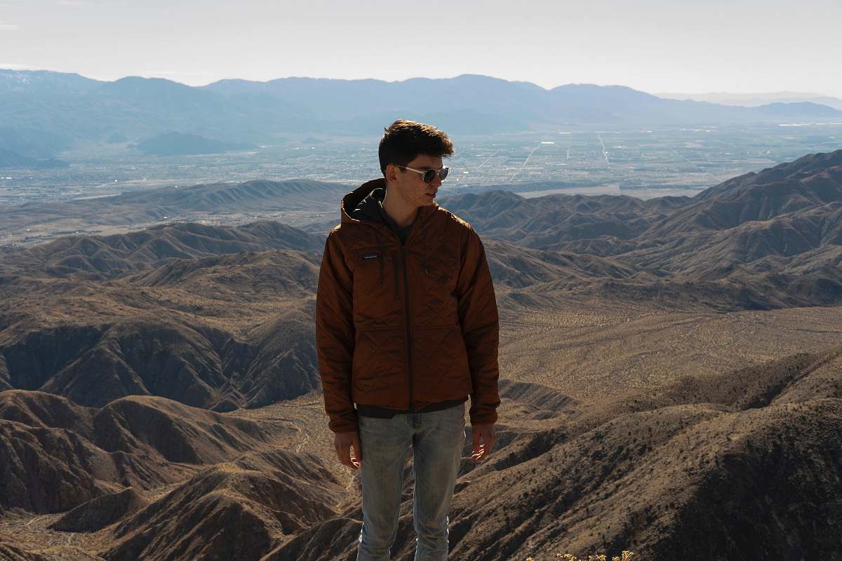 apparel man in brown jacket standing on brown field during daytime clothing