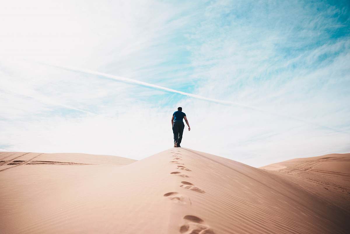 desert man walking on desert dune
