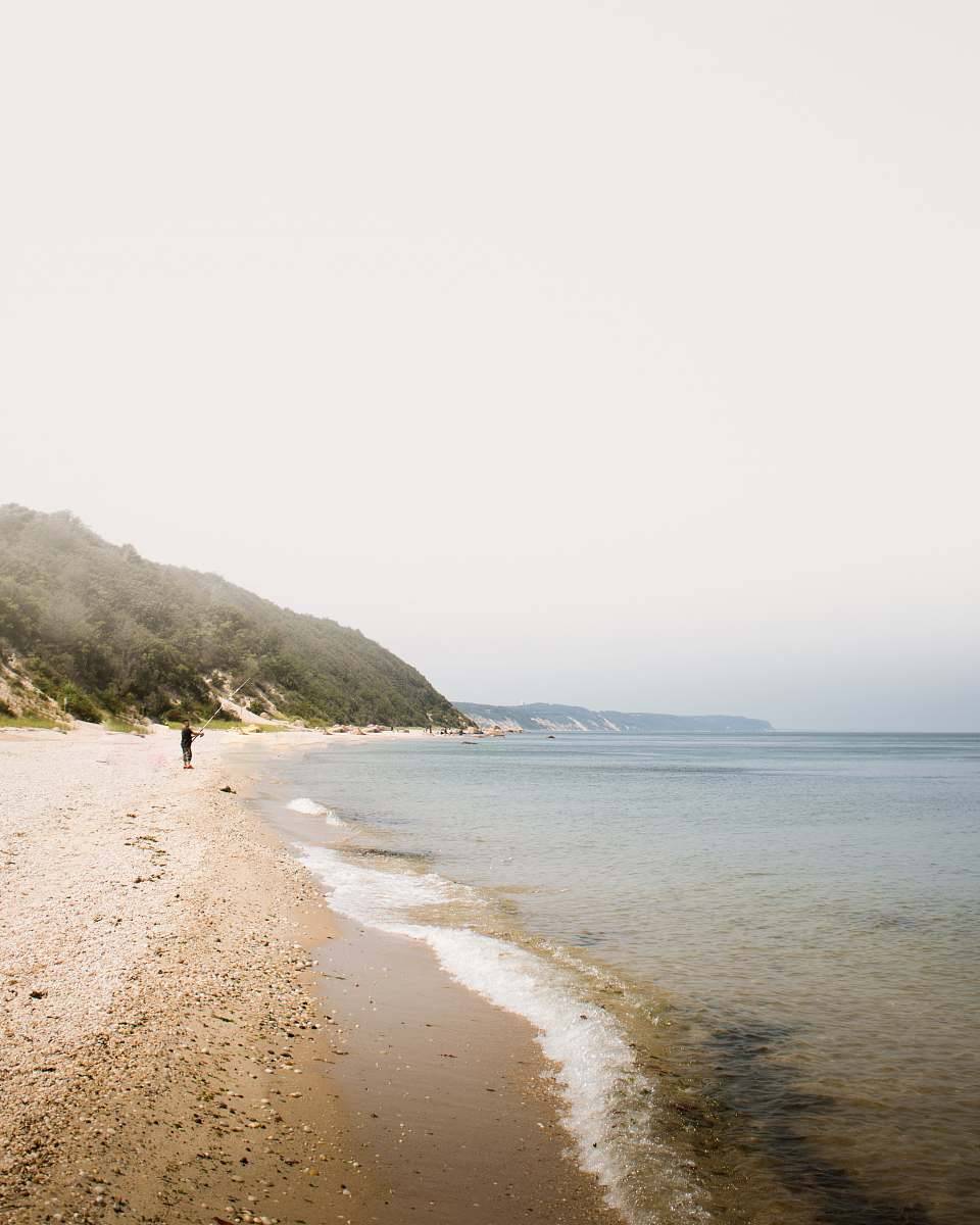 promontory people on beach during daytime ocean