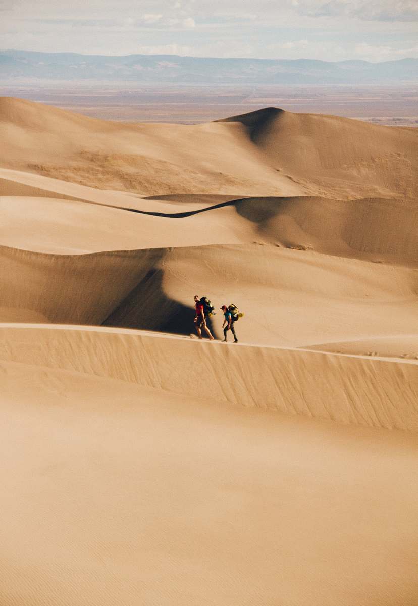desert people walking in the desert during daytime sand