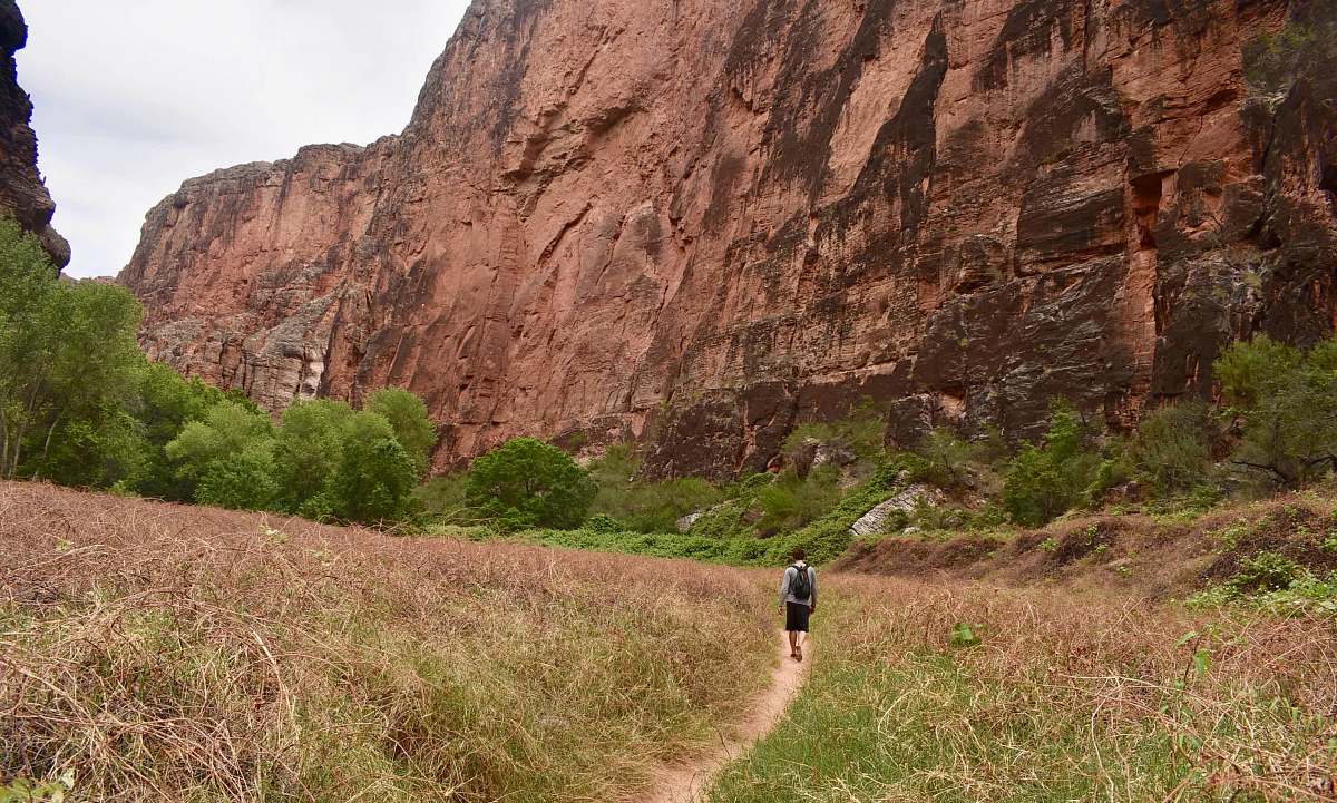 person person walking down the open field towards mountain human