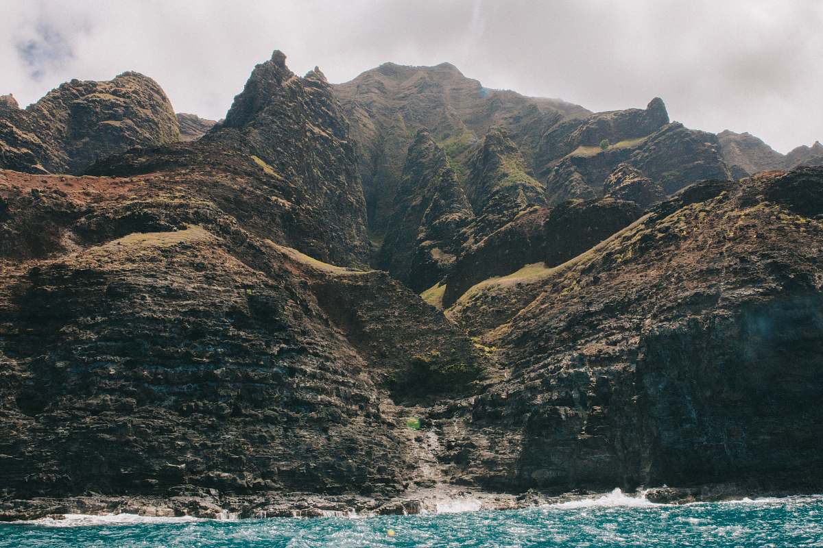 mountain rock mountains near waterfalls under gray sky outdoors