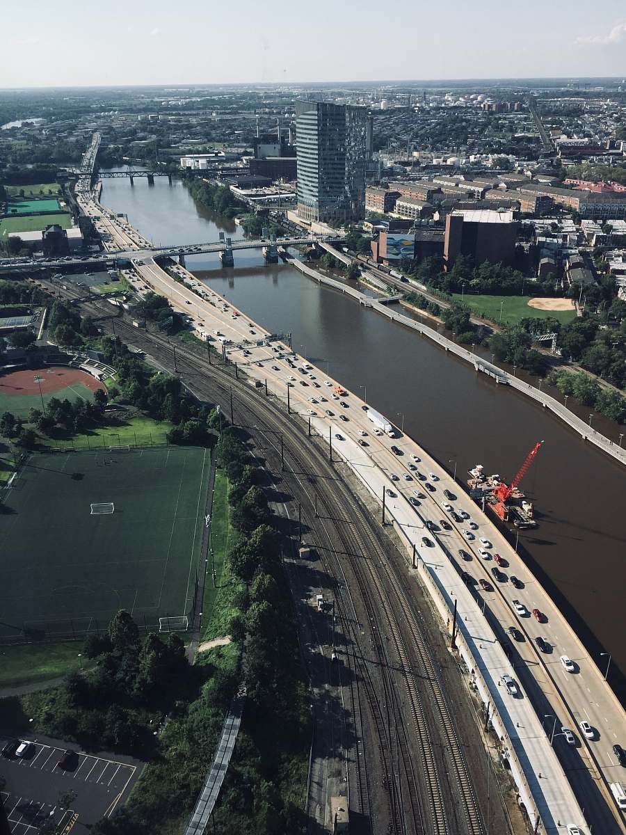 outdoors vehicles on highway beside body of water during daytime landscape