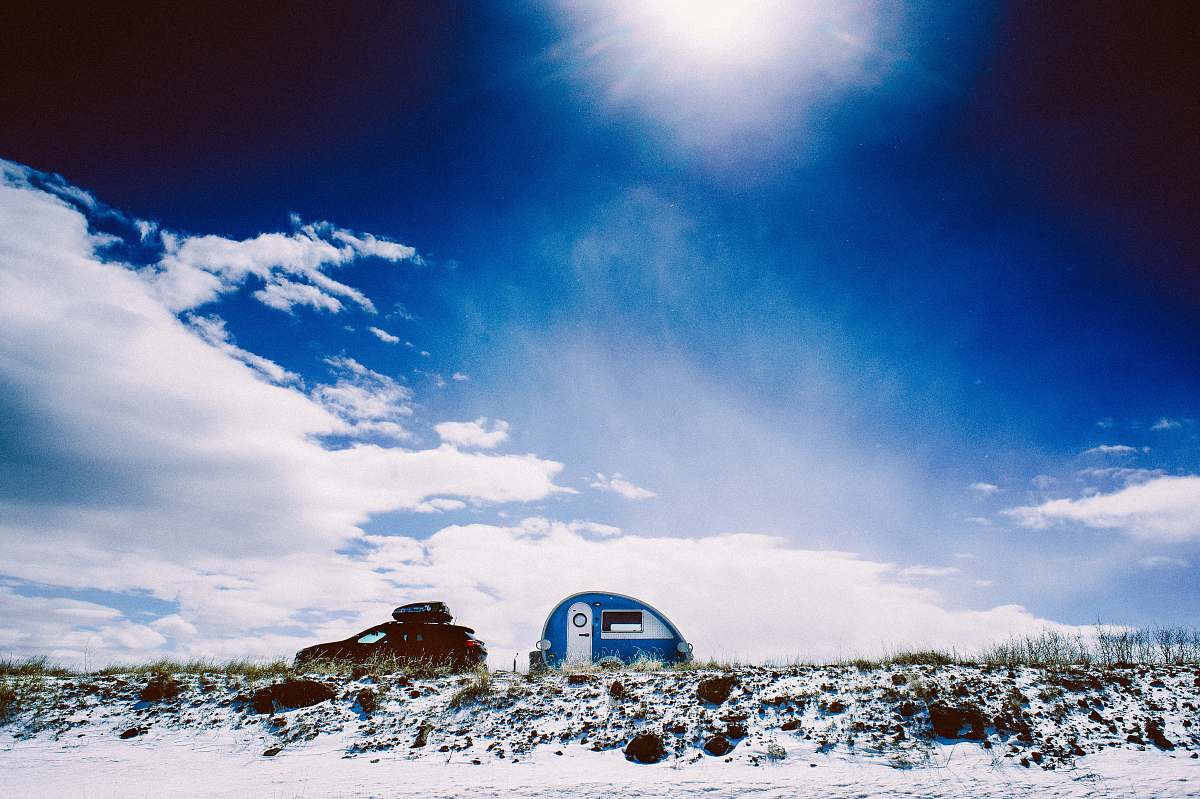 outdoors white and blue trailer under blue calm sky building