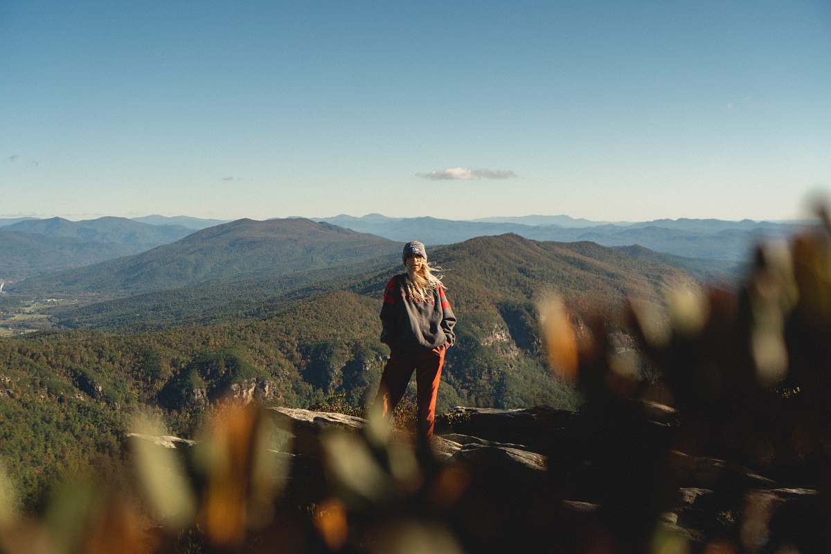 person woman standing on cliff overview of mountain in landscape photography mountain