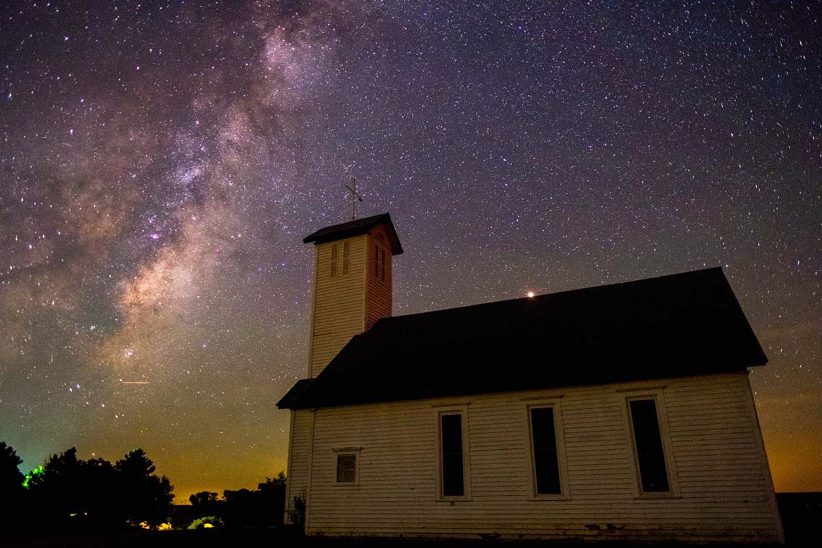 galaxy church near trees during night milky way