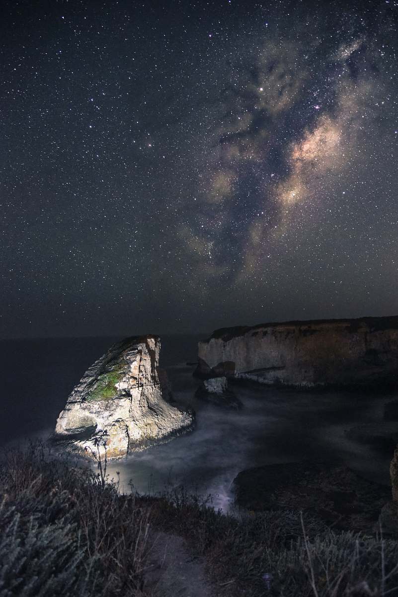 galaxy gray rock on body of water under stars milky way