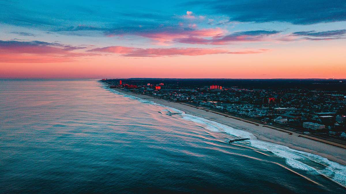 beach aerial photography of buildings near ocean during golden hour water
