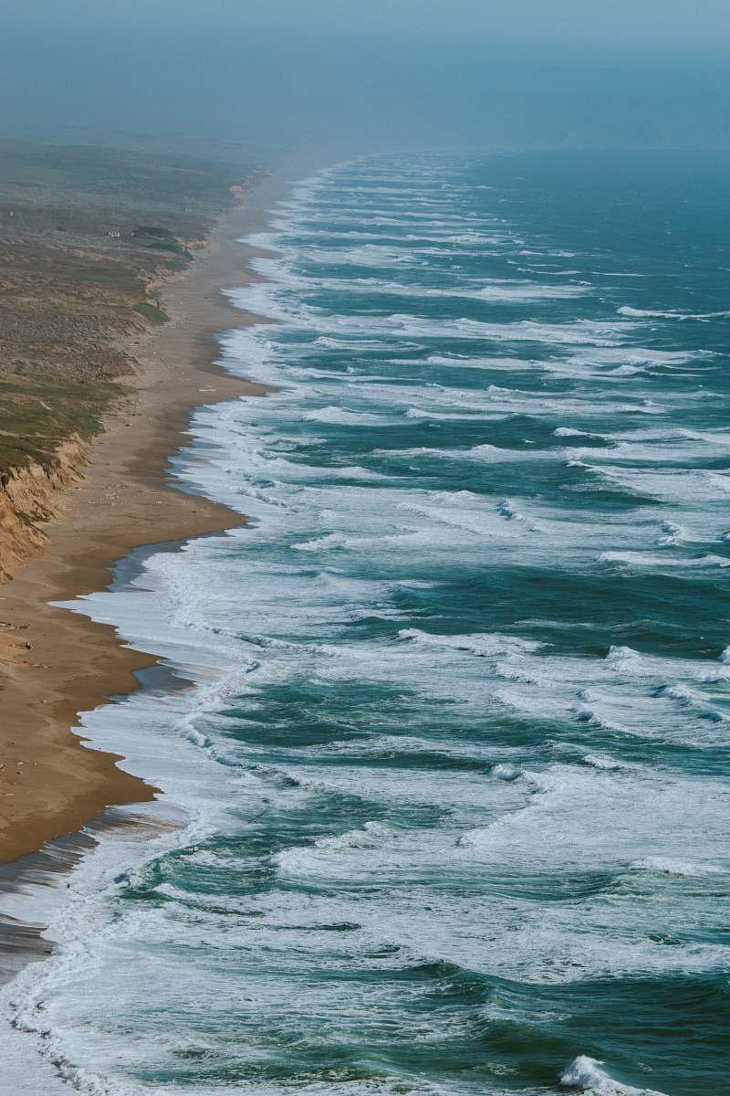beach aerial photography of ocean waves hitting shore coast