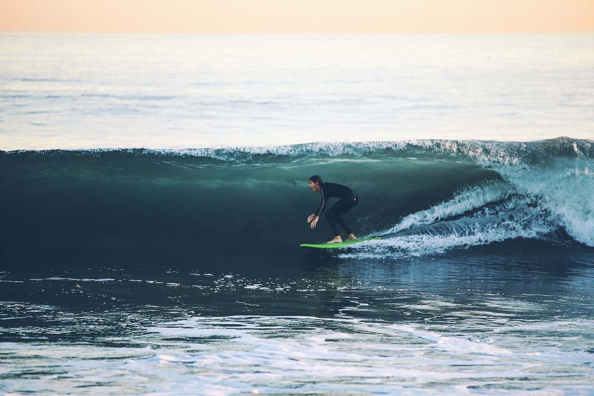 surfing man surfing on sea at daytime water