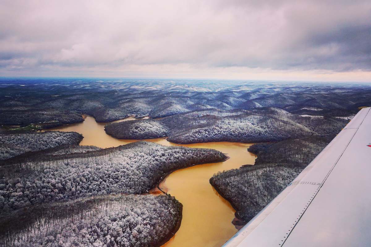 nature airplane wing view of forest and river scenery