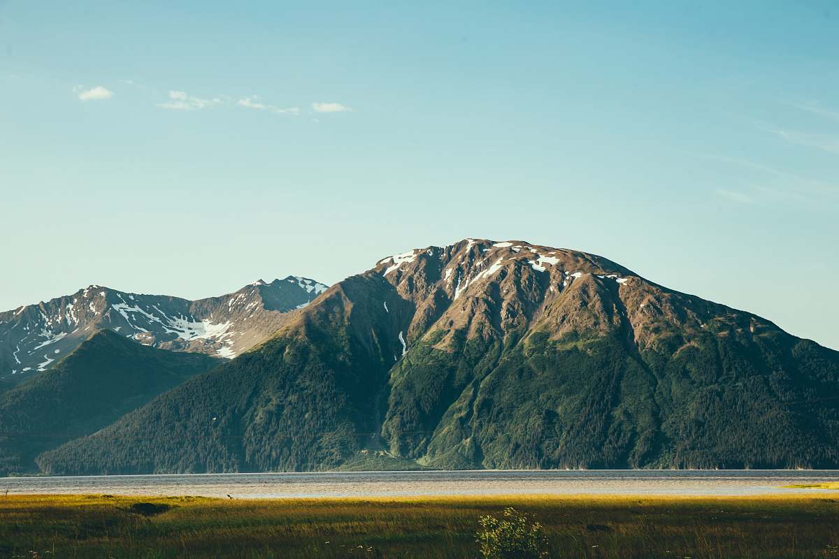 mountain body of water in front of mountain during daytime peak