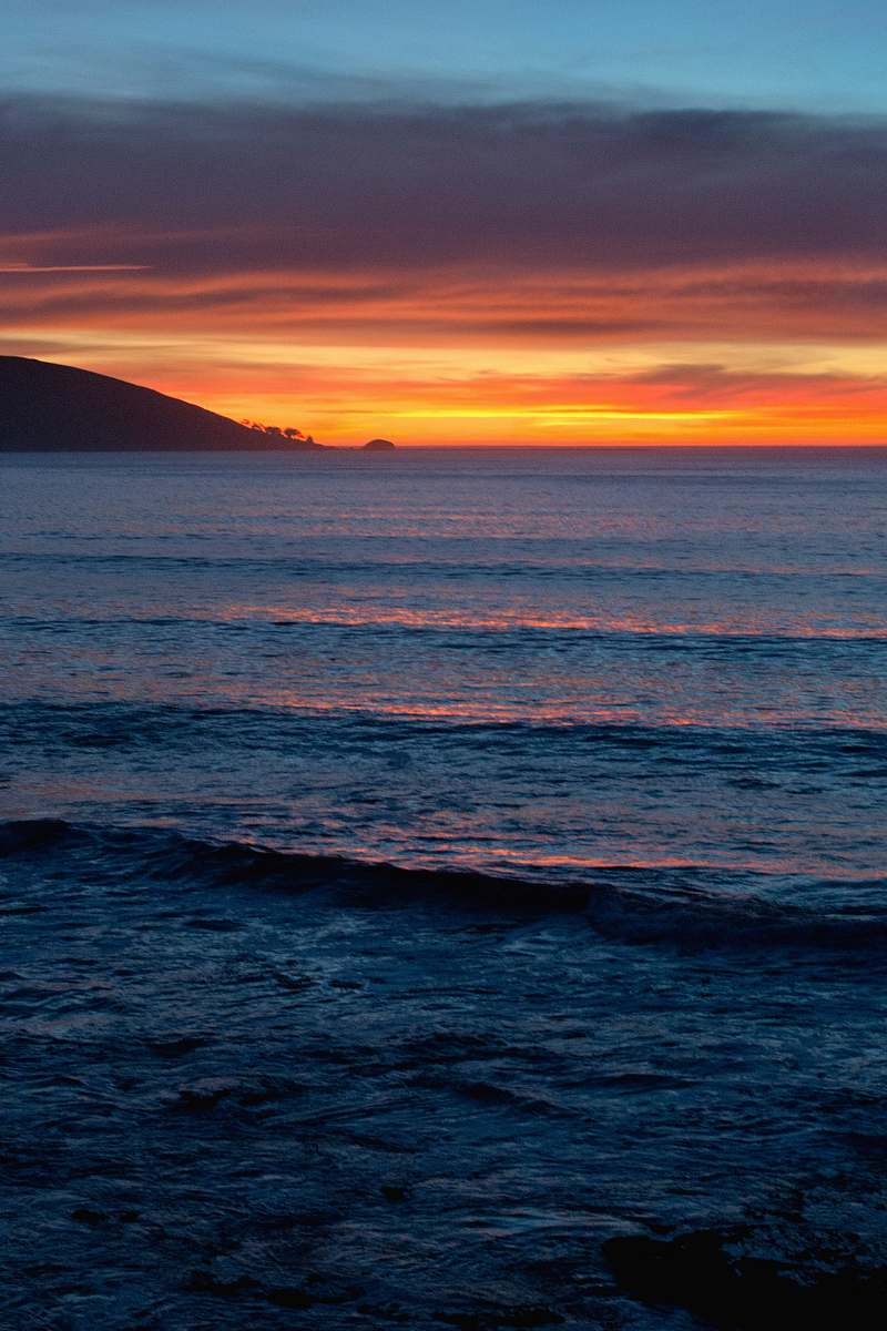 Experience the tranquil beauty of nature as the sun slowly sets over the serene ocean. This stunning imagery captures the vibrant hues of the sunset reflecting on the gentle waves, creating a peaceful ambiance perfect for relaxation or inspiration. Ideal for use in travel blogs, environmental campaigns, or as a calming background for meditation and wellness content.