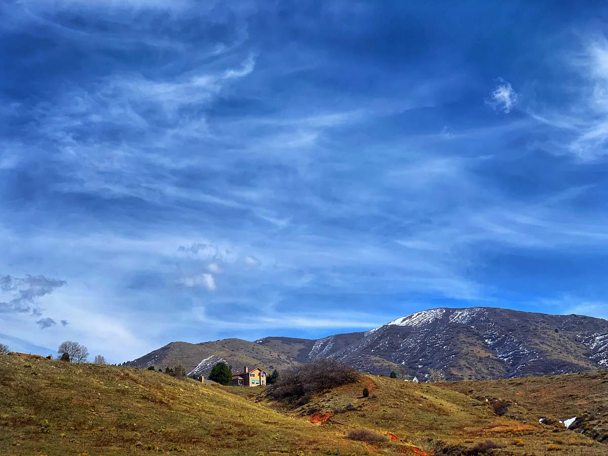 nature green grass field near mountain under blue sky during daytime mountain