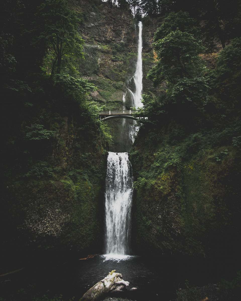 waterfall waterfall in between mountains with bridge river