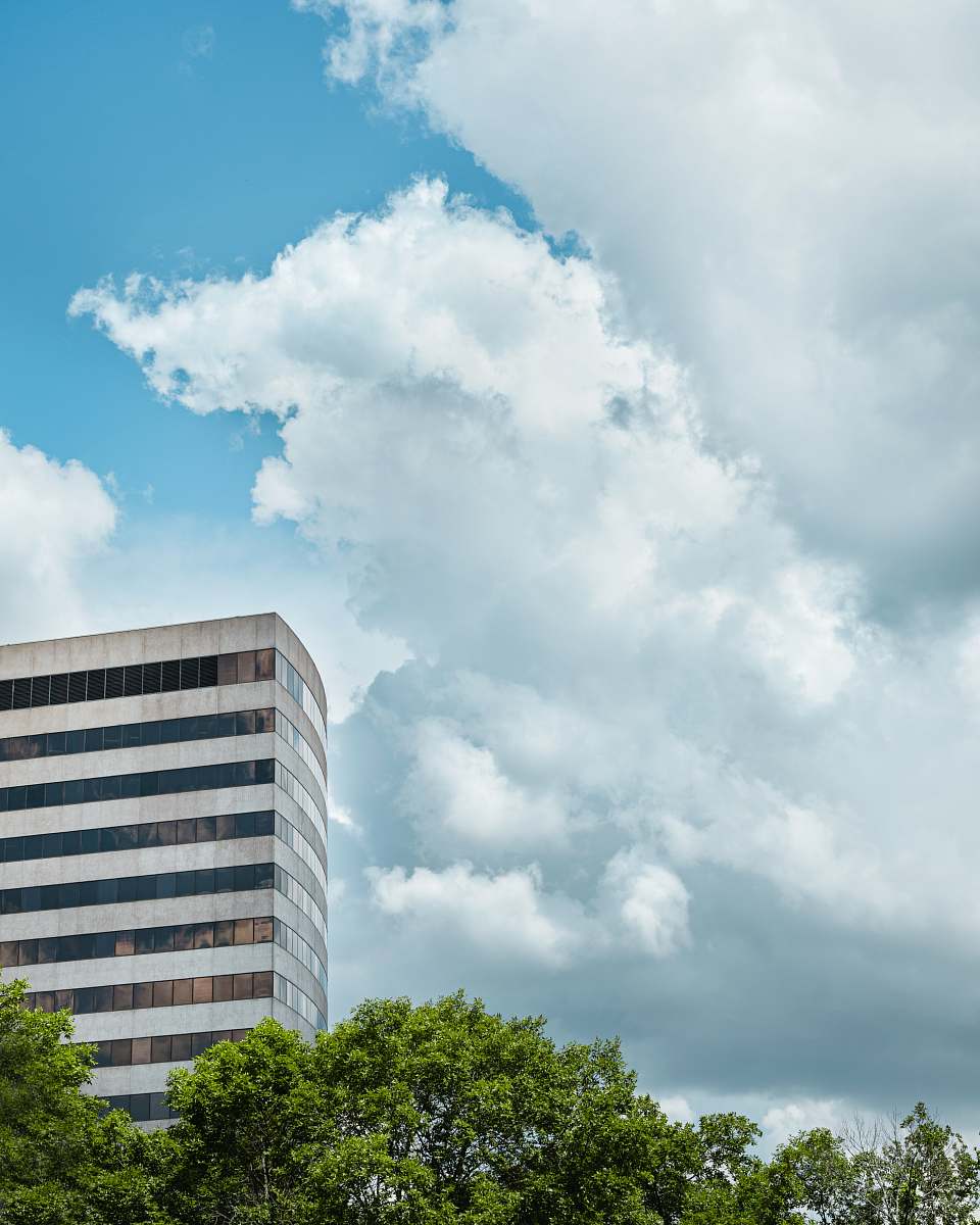 building white concrete multi-storey building under cloudy sky during daytime office building