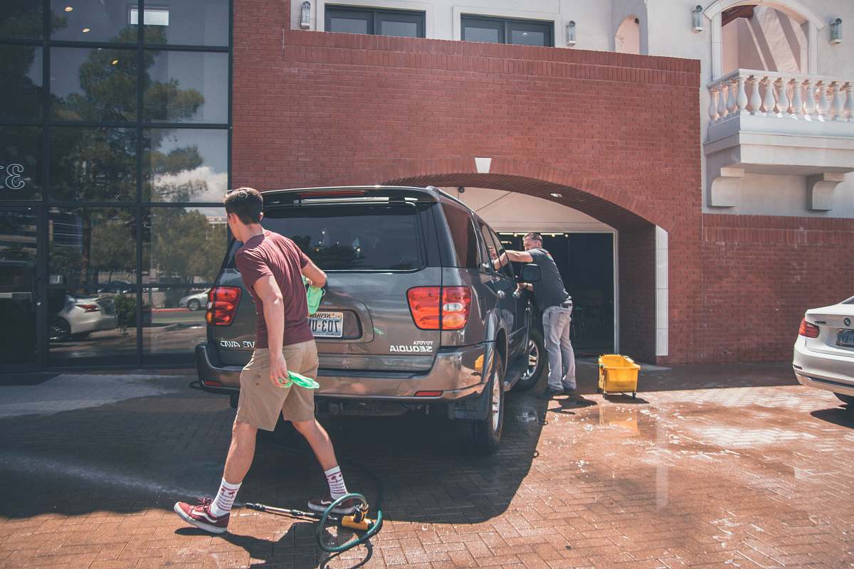 human man cleaning silver SUV person