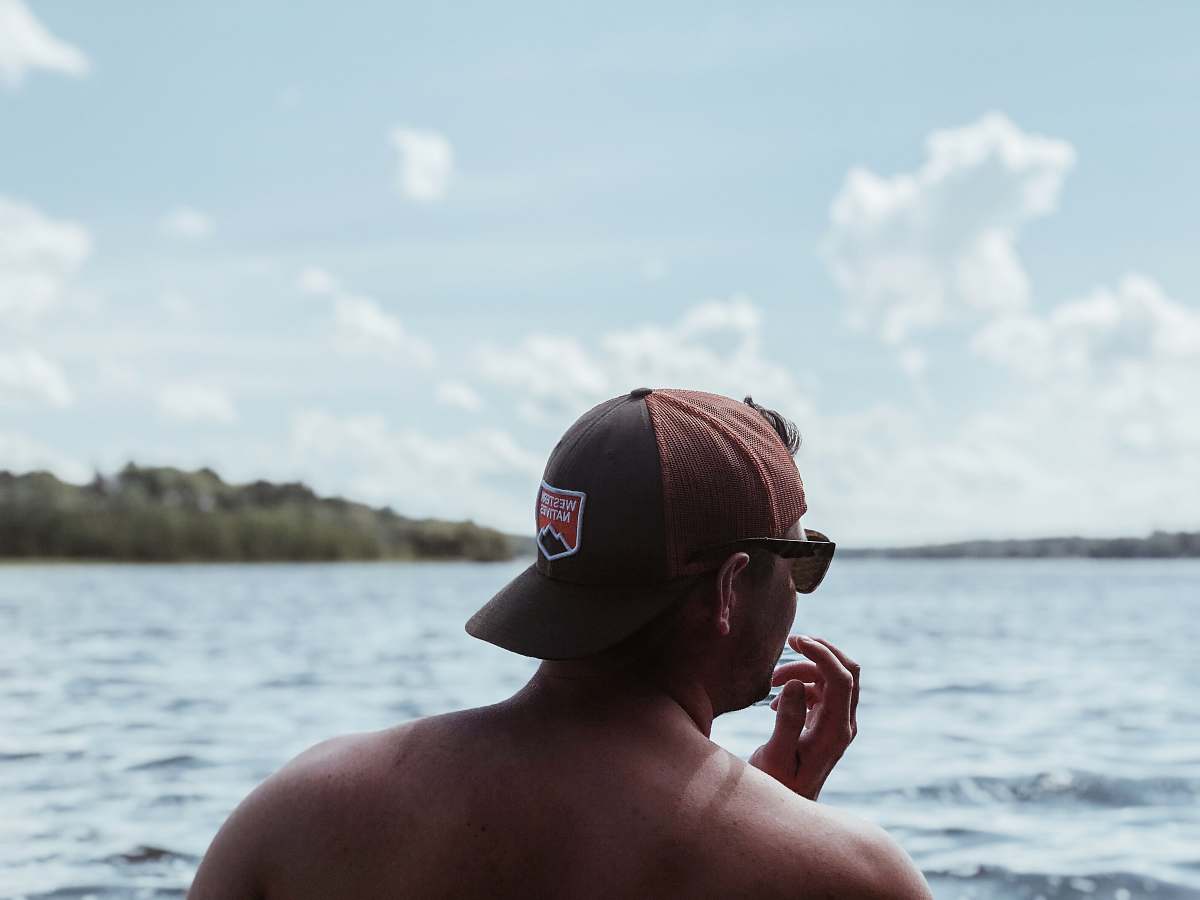 human man standing near sea under white clouds during daytime person