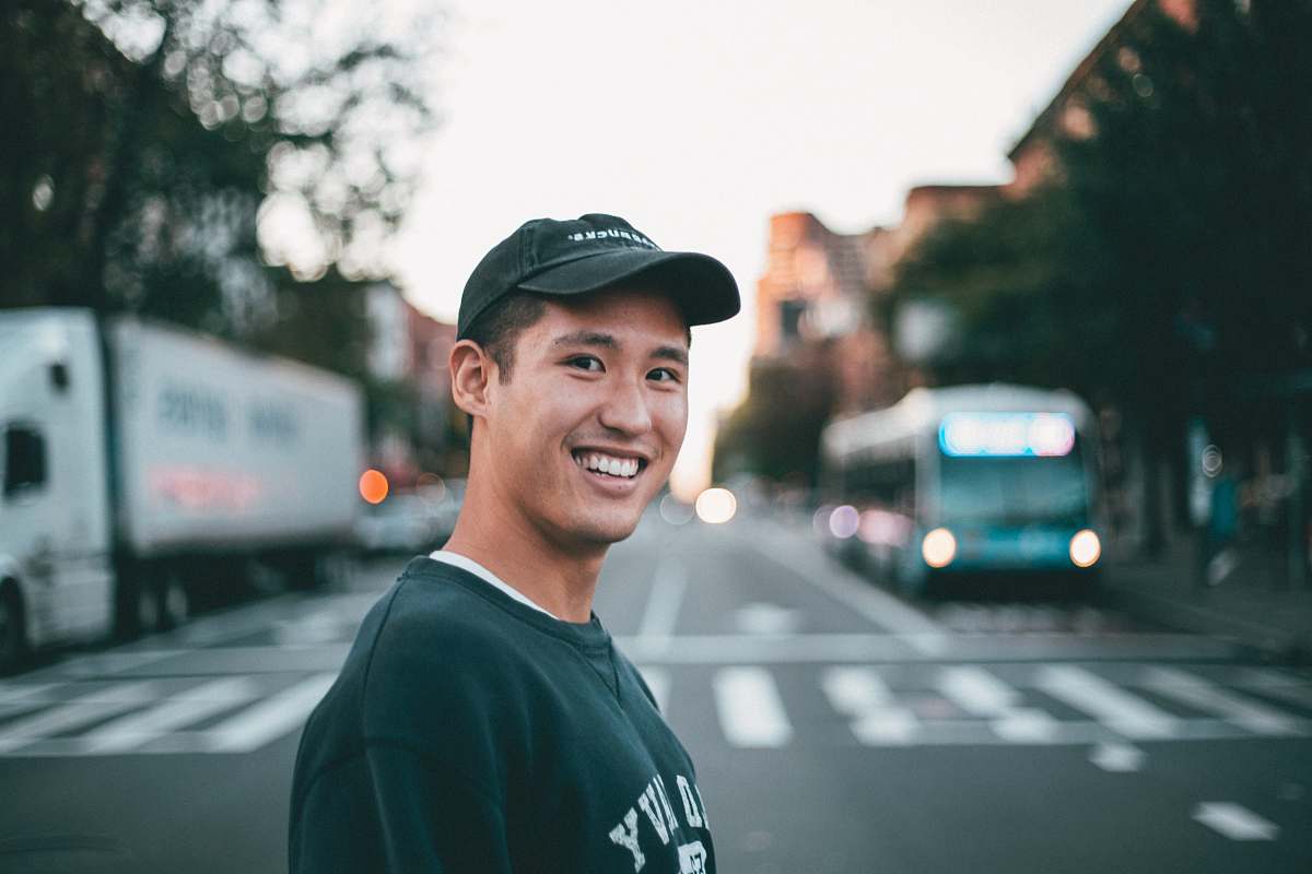 person man stranding on straight road photo during daytime human