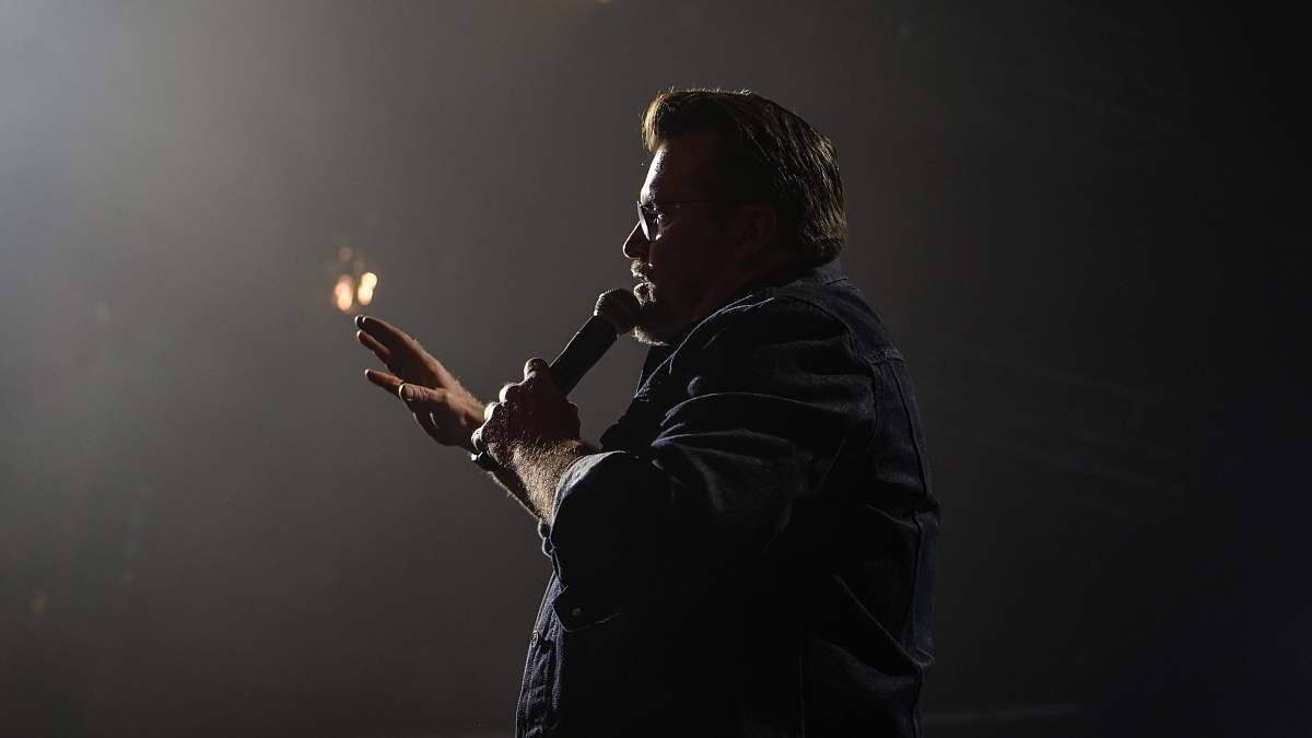 human man in black jacket holding microphone columbus