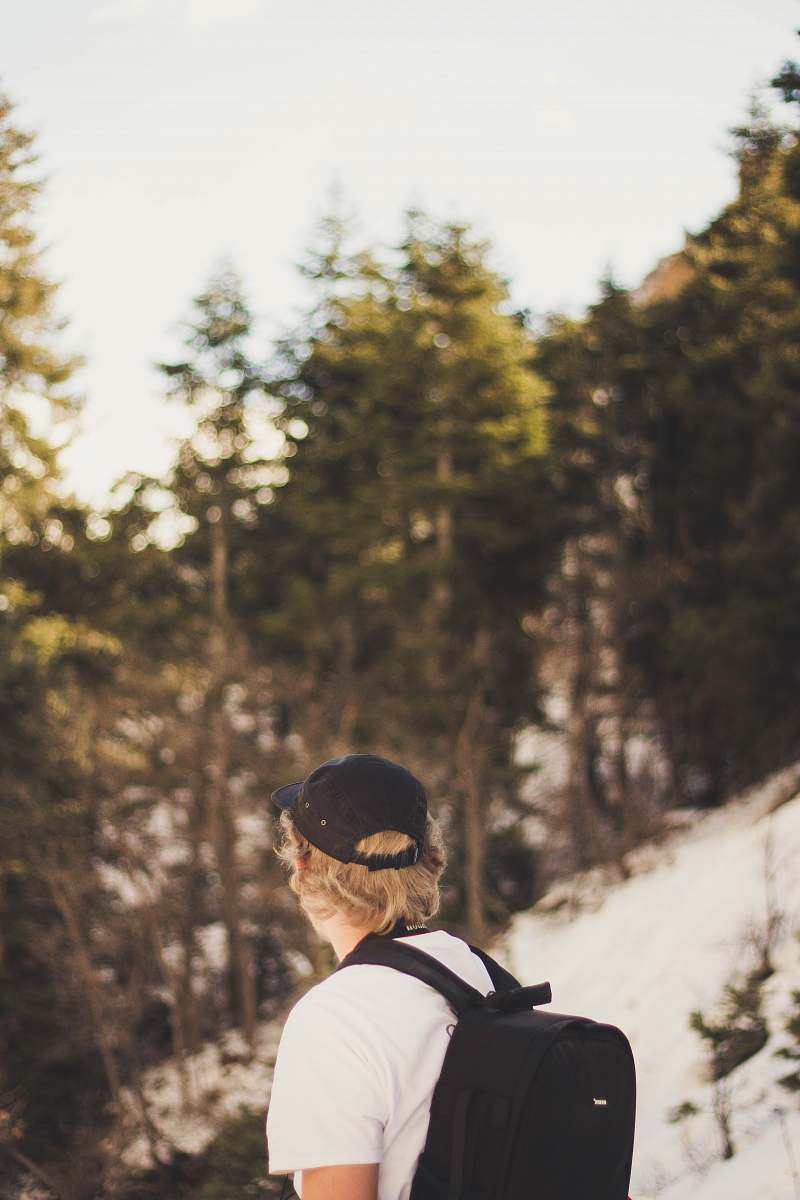 human man in white shirt with black backpack people