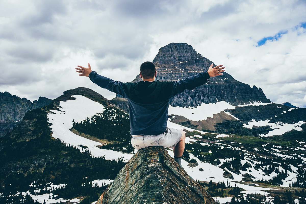 people man sitting on cone rock spreading hands human