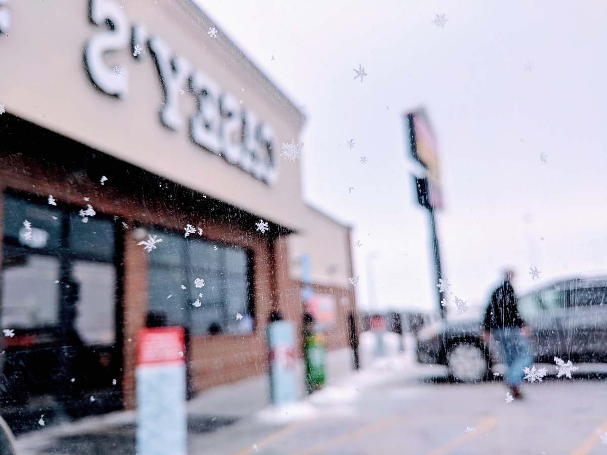 human man walking to the car in front of Casey's building during daytime path