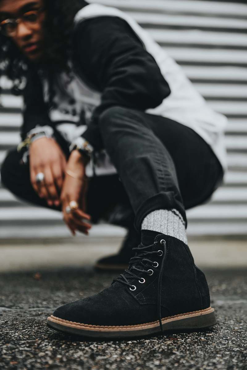 human man wearing black and gray sweatshirt kneeling on ground people