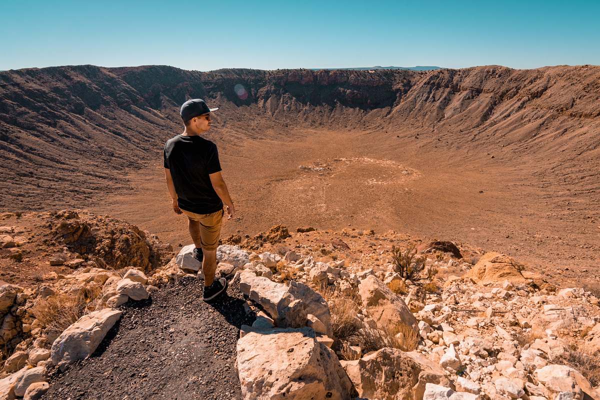 mountain man wearing black shirt standing on rock formation during daytime human