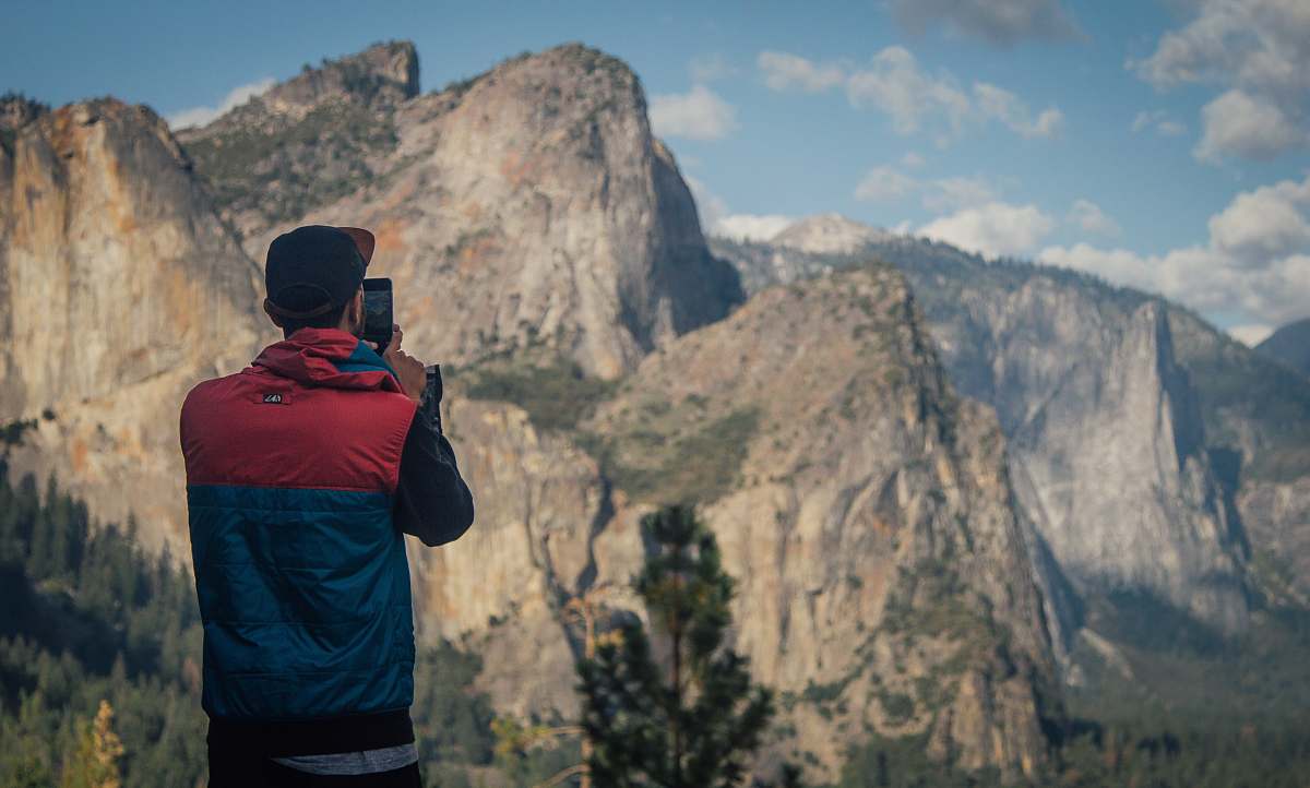 people person taking photo of mountains during daytime mountain range
