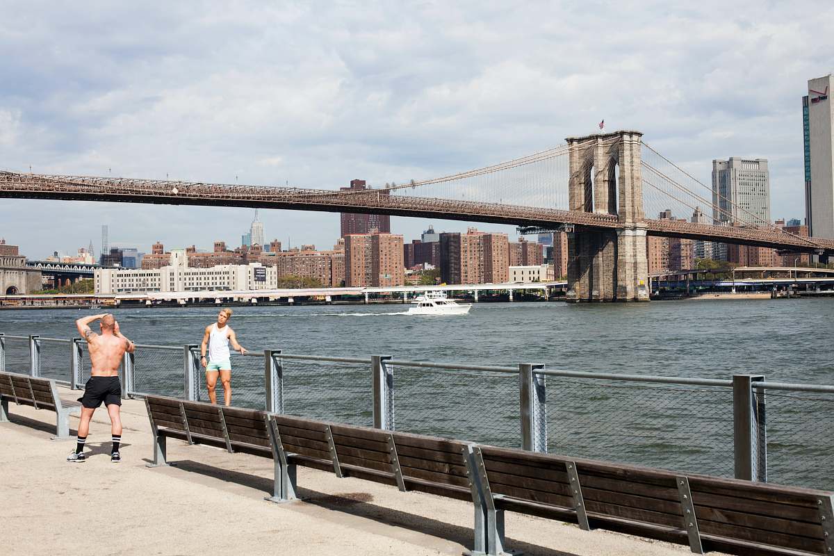 human two men taking picture in front of Brooklyn Bridge people