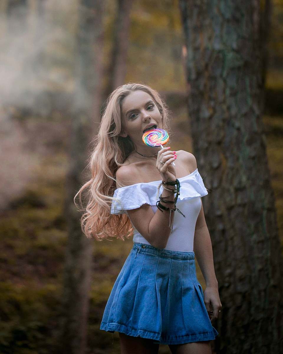 human woman holding lollipop near the tree trunk people