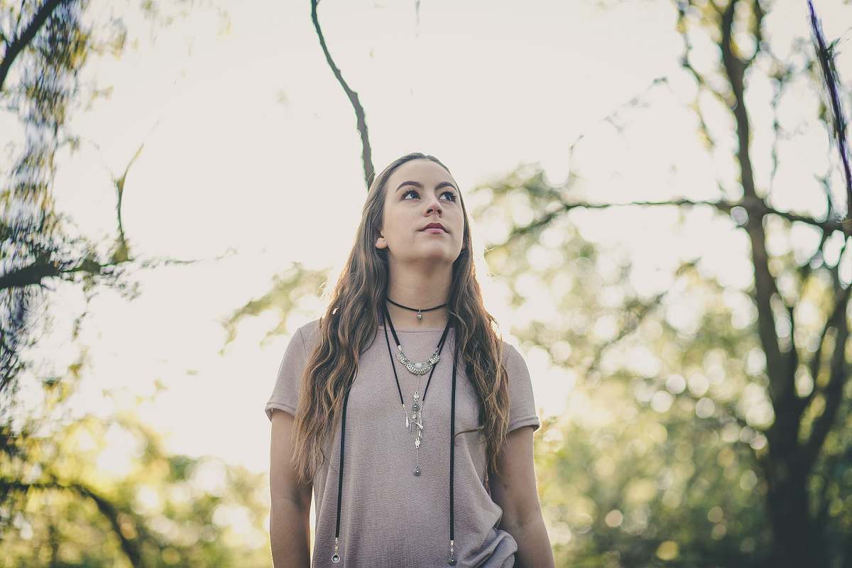 people woman in gray t-shirt standing between tree branches human