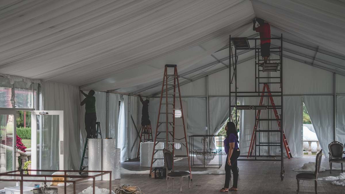 human woman supervising a group of men decorating people