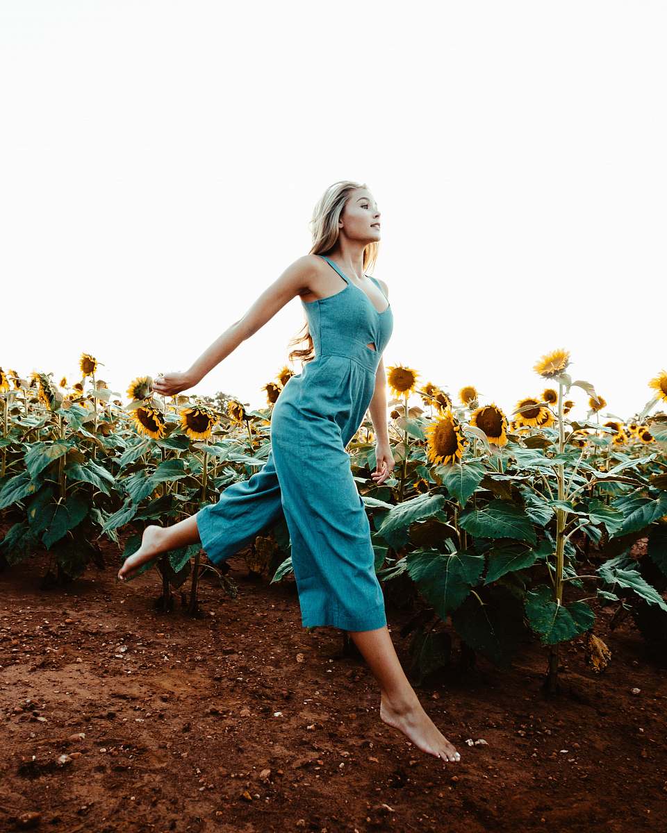 human woman walking near the sunflower field at daytime people
