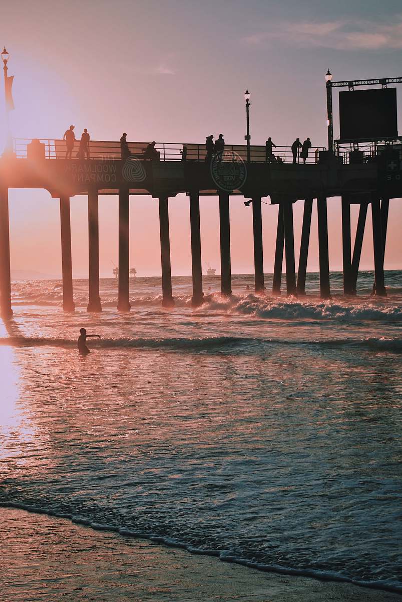 dock people standing on dock above body of water huntington beach