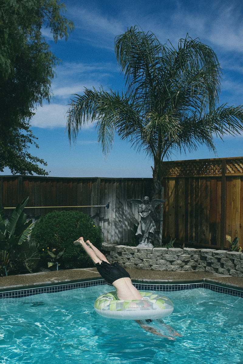 resort person diving on below ground pool under blue sky swimming pool