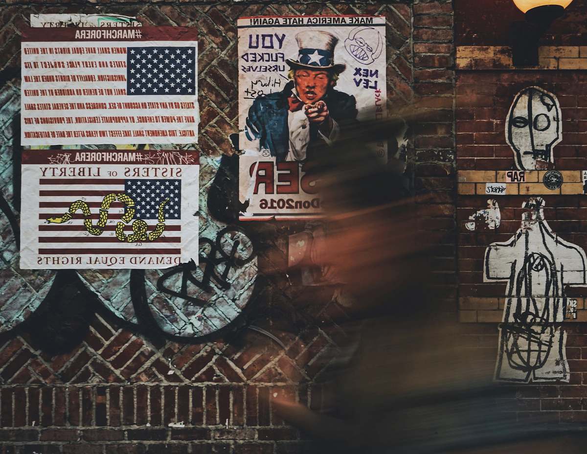 graffiti woman passing by near Uncle Sam poster at the street 112 brunswick st